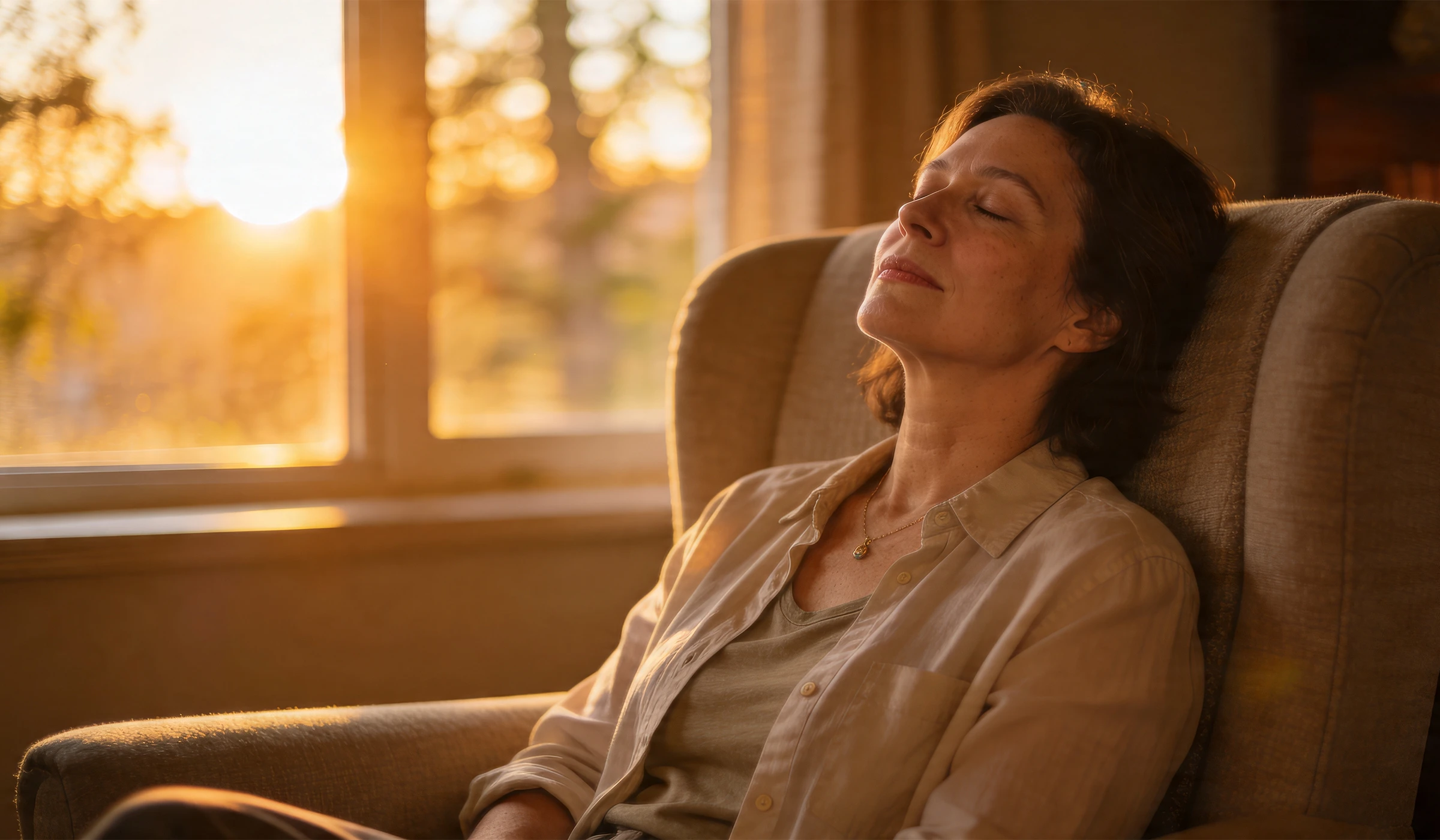 Vrouw ontspant thuis in een fauteuil tijdens een energetische schoning op afstand van Leven op gevoel