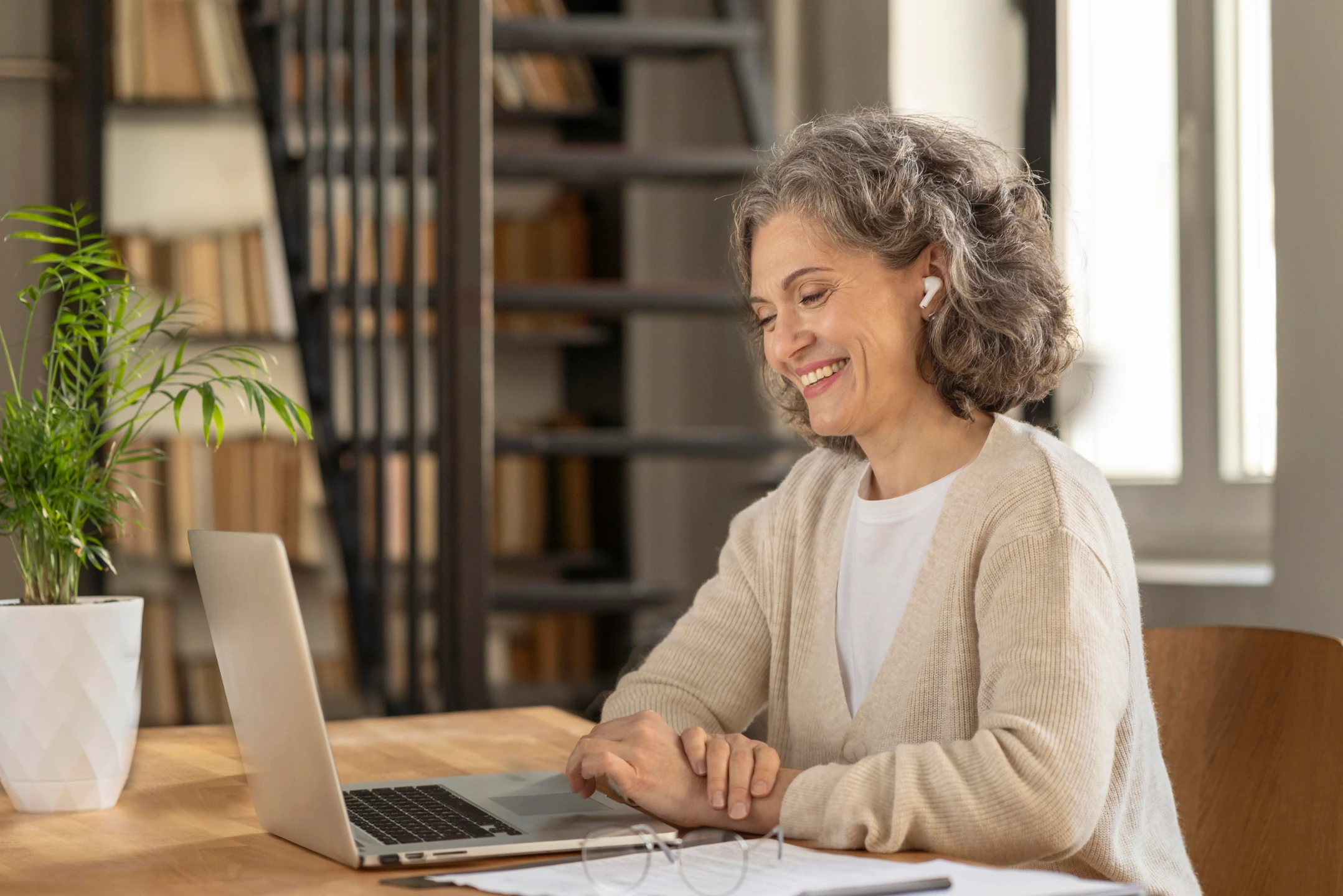 Vrouw volgt een online sessie thuis via Zoom